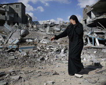 A Palestinian woman weeps as she walks amid destroyed buildings in Beit Hanoun town, which witnesses said was heavily hit by Israeli shelling and air strikes during an Israeli offensive, in the northern Gaza Strip July 26, 2014. A 12-hour humanitarian truce went into effect on Saturday after Israel and Palestinian militant groups in the Gaza Strip agreed to a U.N. request for a pause in fighting and efforts proceeded to secure a long-term ceasefire moved ahead. REUTERS/Finbarr O'Reilly (GAZA - Tags: POLITICS MILITARY CIVIL UNREST) - RTR4071S