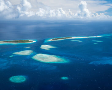 Aerial view of some of the islands an islets of Kwajalein Atoll, Marshall Islands. One of the first groups of islands that will disappear due to sea level rise because of climate change. Ebeye Island is one of the most populated pieces of land on Earth. The US Army Garrison Kwajalein Atoll is in this atoll.