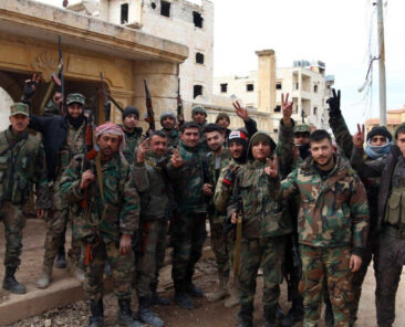 In this photo released Sunday, Feb. 16, 2020 by the Syrian official news agency SANA, Syrian army soldiers flash the victory sign in the Rashideen neighborhood, in Aleppo province, Syria. Syria's military announced on Monday that its troops have regained control of territories in northwestern Syria "in record time," vowing to continue to chase armed groups "wherever they are." (SANA via AP)
