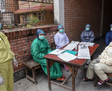 Health workers wearing protective gear wait for patients at a health centre during a government-imposed lockdown as a preventive measure against the COVID-19 coronavirus, in Kathmandu on April 22, 2020. (Photo by PRAKASH MATHEMA / AFP)