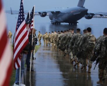FILE - In this Saturday, Jan. 4, 2020, file photo, this photo provided by the U.S. Army, paratroopers assigned to 1st Brigade Combat Team, 82nd Airborne Division walk as they prepare equipment and load aircraft bound for the U.S. Central Command area of operations from Fort Bragg, N.C. A push led by pro-Iran factions to oust U.S. troops from Iraq is gaining momentum, bolstered by a Parliament vote in favor of a bill calling on the the government to remove them. But the path forward is unclear. (Spc. Hubert Delany III/U.S. Army via AP, File)