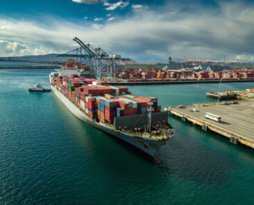 Aerial shot of a massive cargo ship arriving in the Port of Long Beach, California.