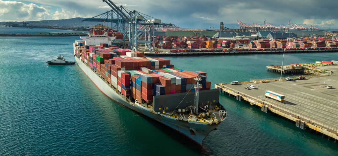 Tug Boat Maneuvering Cargo Ship at Dockside in Port of Long Beach