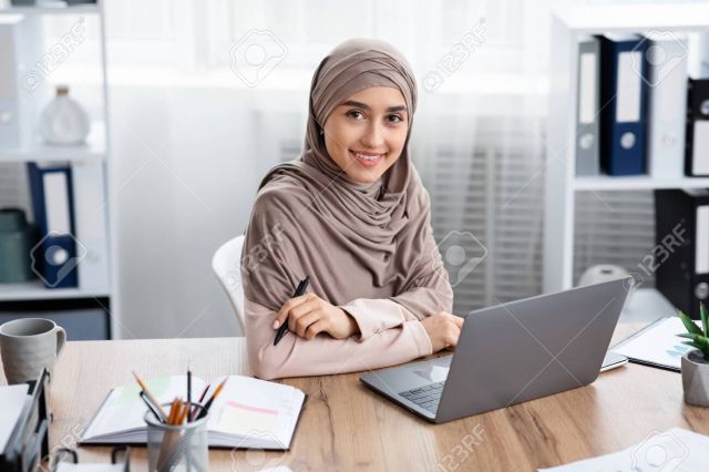 Millennial Muslim Girl In Headscarf Posing At Workplace In Modern Office