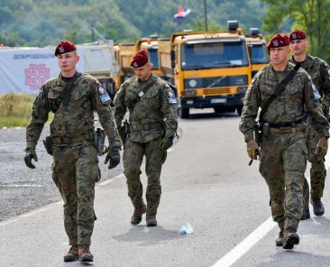FILE PHOTO: Polish soldiers, part of a NATO peacekeeping mission in Kosovo pass through barricades near the border crossing between Kosovo and Serbia in Jarinje, Kosovo, September 28, 2021. REUTERS/Laura Hasani/File Photo