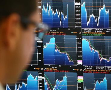 LONDON, ENGLAND - OCTOBER 20: An employee views trading screens at the offices of Panmure Gordon and Co on October 20, 2014 in London, England. Markets stabilised over the weekend following global turbulence amid fears over the Ebola virus and global economic concerns. (Photo by Carl Court/Getty Images)